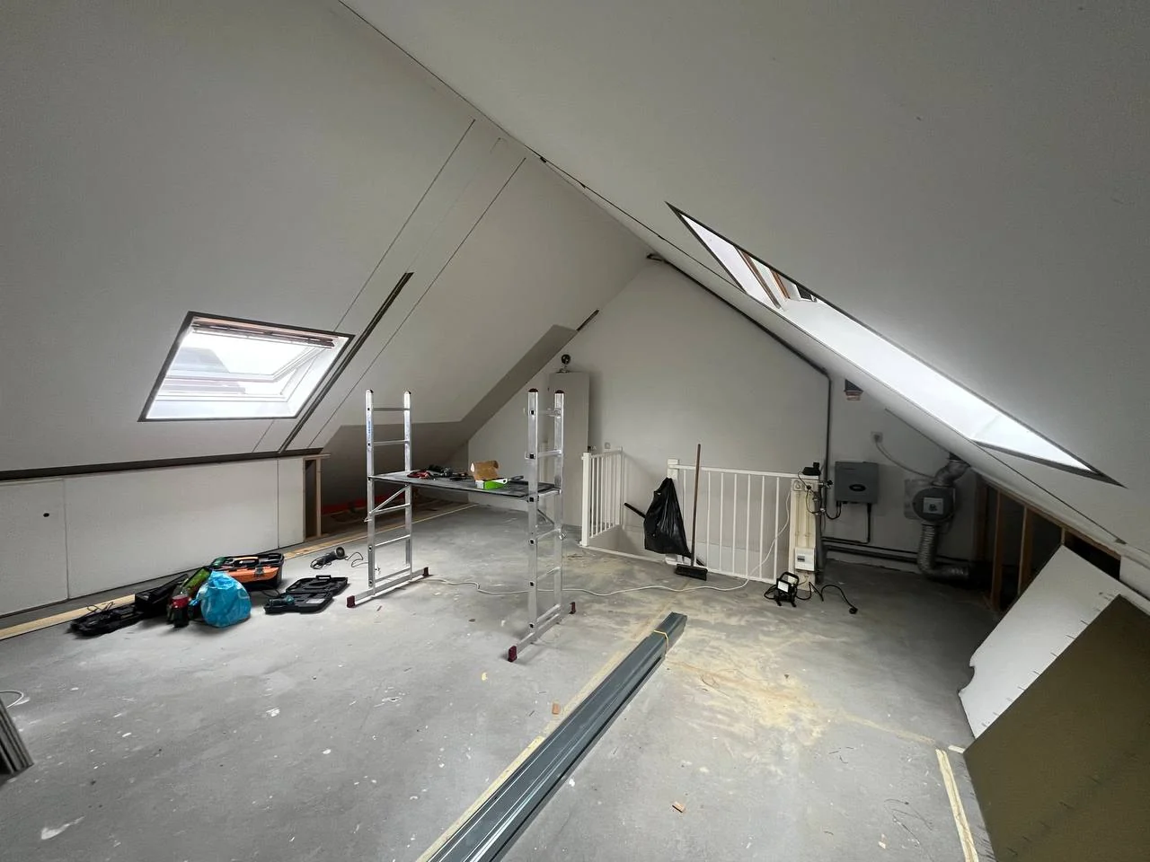 Zolder met gipsplaten op schuine wanden rond dakramen